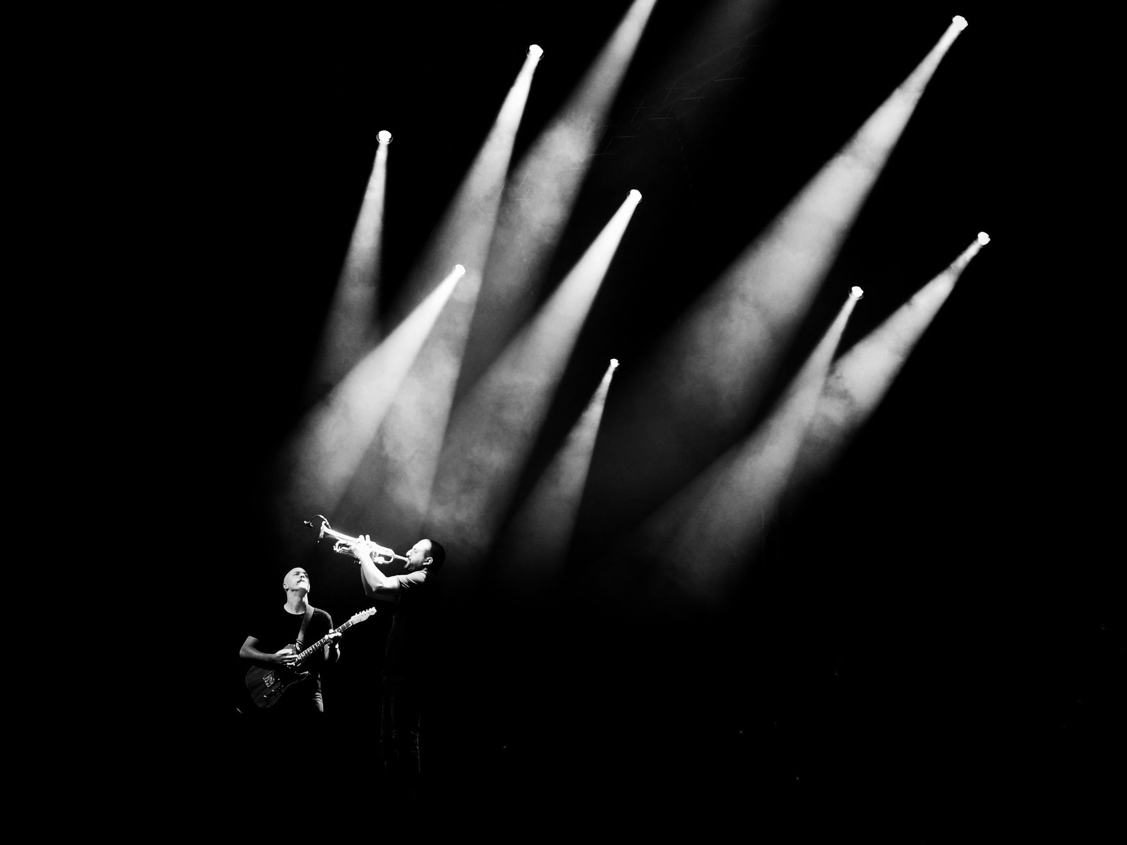 Musicians performing under dramatic stage spotlights